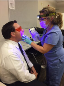 Firefighter Lisa Evans, RDH, BA, EMT, conducts an oral cancer screening