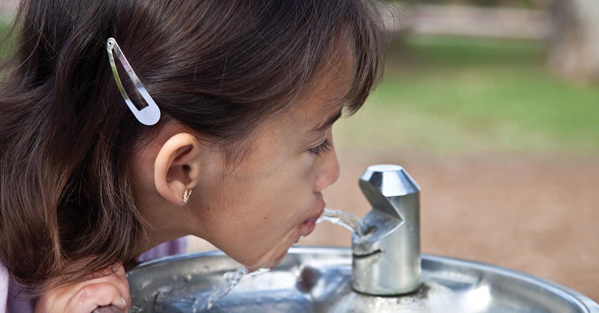 Girl drinking water with fluoride