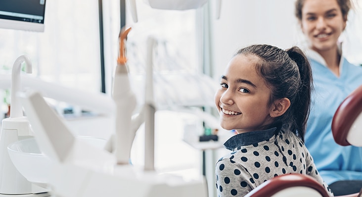 young girl smiling in dentist chair