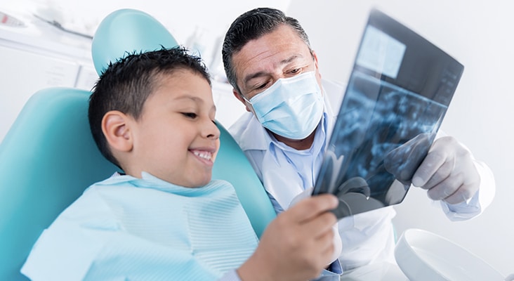 dentist and young boy looking at xrays