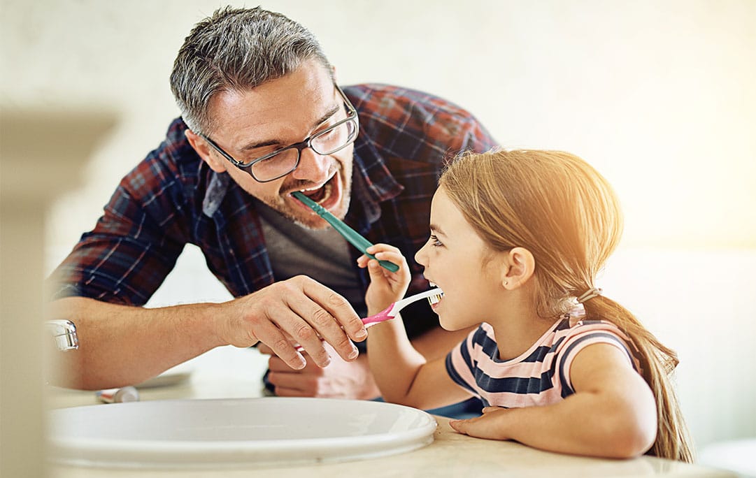 Parent brushing child's teeth