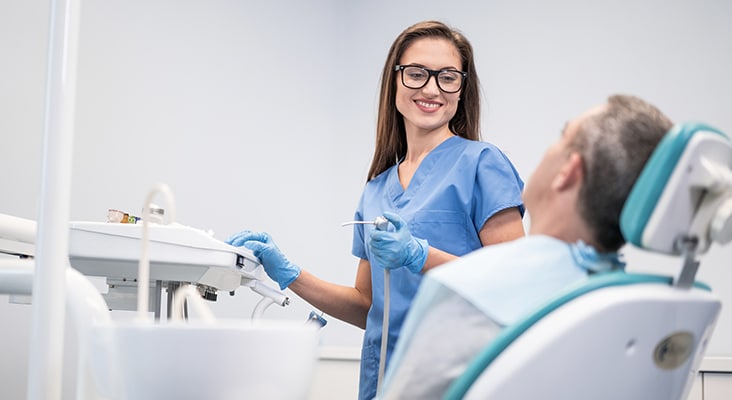 Mid adult man having teeth examined at dentists