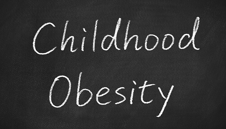 childhood obesity concept words on a chalkboard background