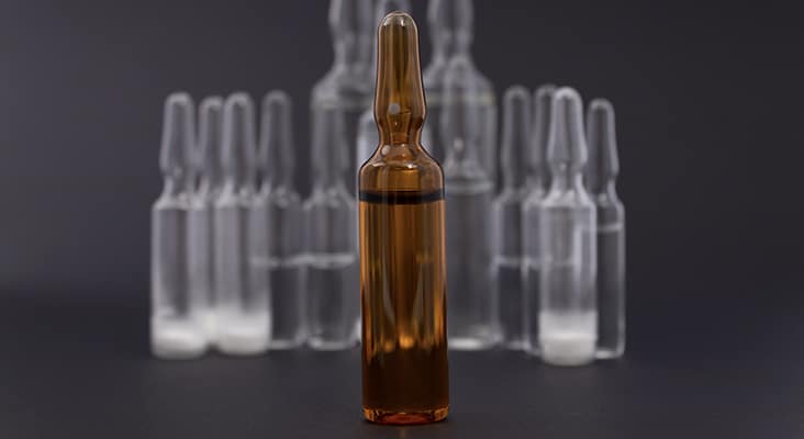 Brown ampoule close-up on the background of drugs