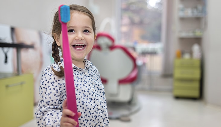 ovely toddler visiting the dentist, having an examination.