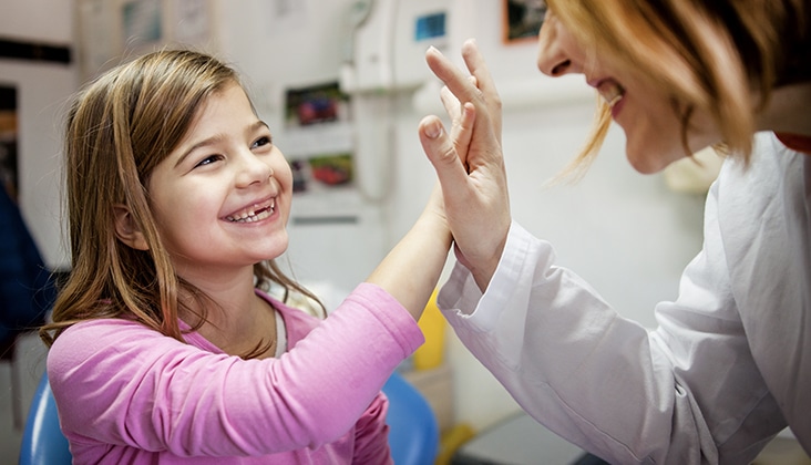 girl giving dentist high five