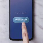 finger pressing subscribe on phone