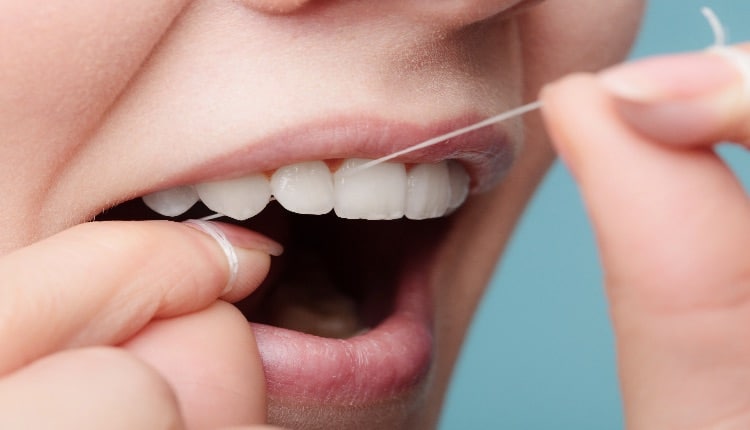 side view woman face smiling with dental floss