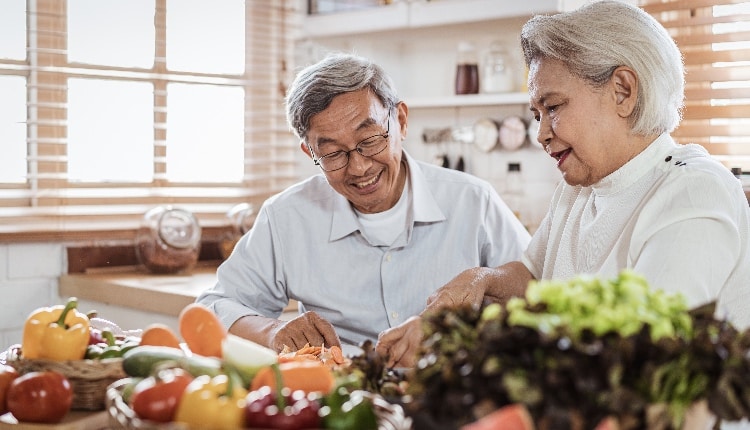 Senior asian couple cooking together in kitchen