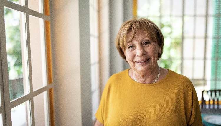 Portrait of smiling senior woman near window