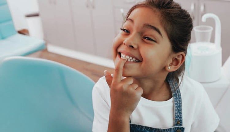 girl pointing at teeth