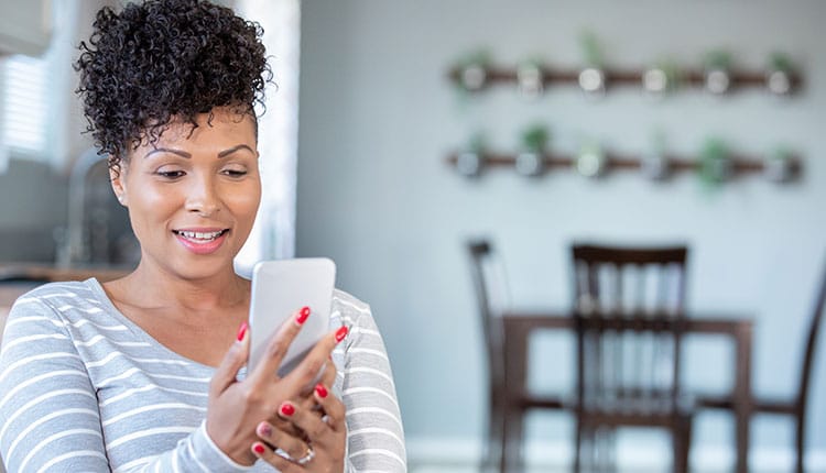 Woman uses smart phone for virtual doctor's appointment from home