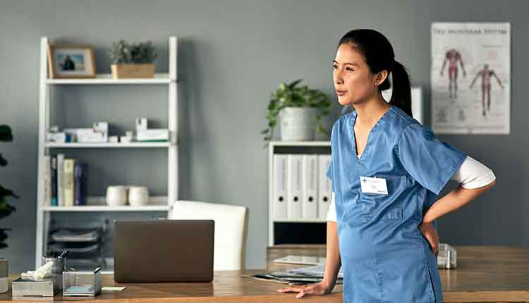 Shot of a female medical practitioner experiencing back pain