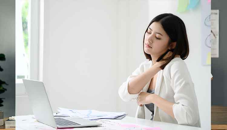 Office syndrome concept. Young asian businesswoman feeling pain in neck after working on computer laptop for a long time