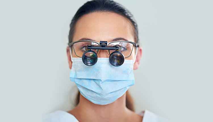 Portrait of a young female dentist wearing magnifying glasses