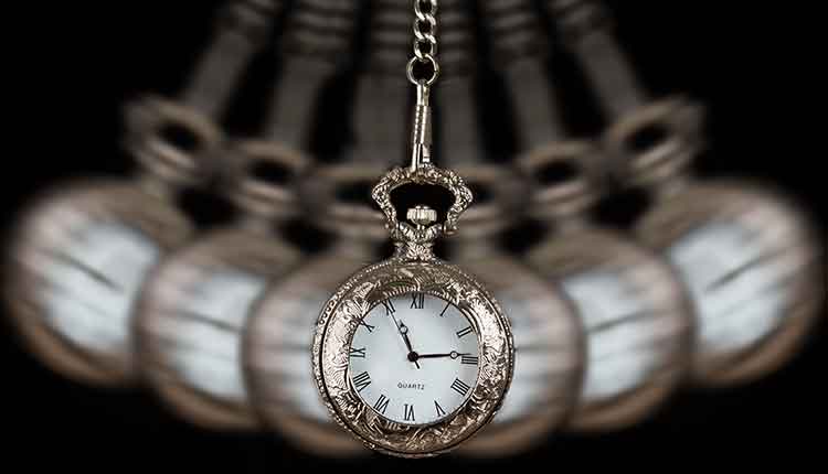 Pocket watch silver swinging on a chain black background to hypnotize