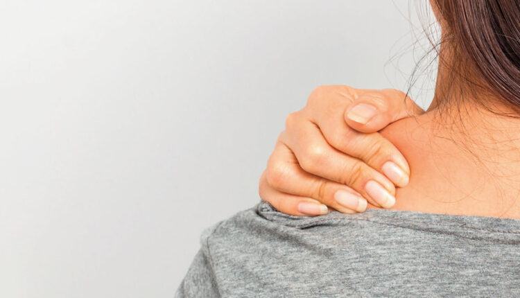 Woman rubbing shoulder, experiencing pain