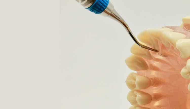 close up of dental tool and mouth