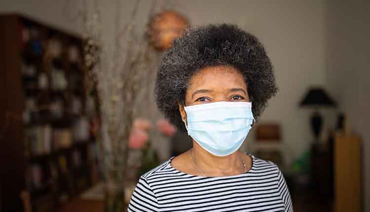 Senior Woman home quarantined with face mask