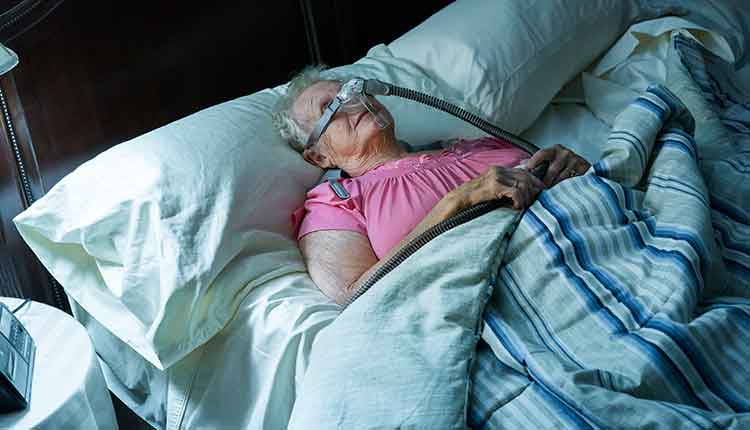 elderly woman in bed with cpap machine