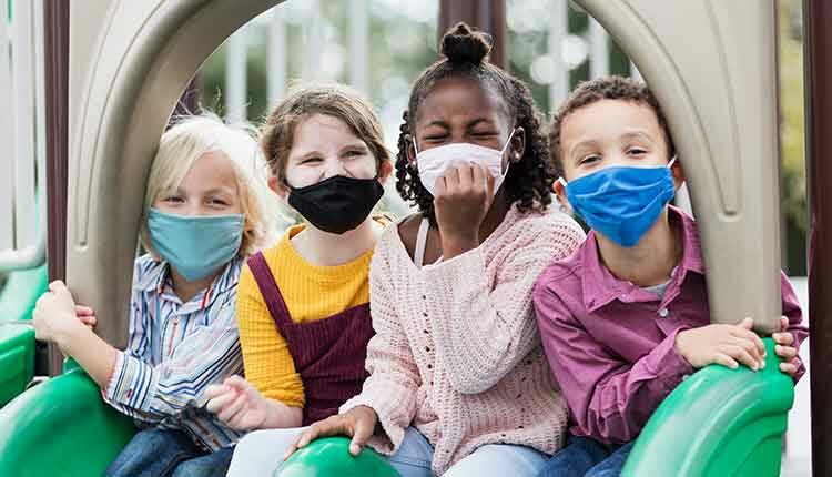 Children on playground wearing face masks, COVID-19