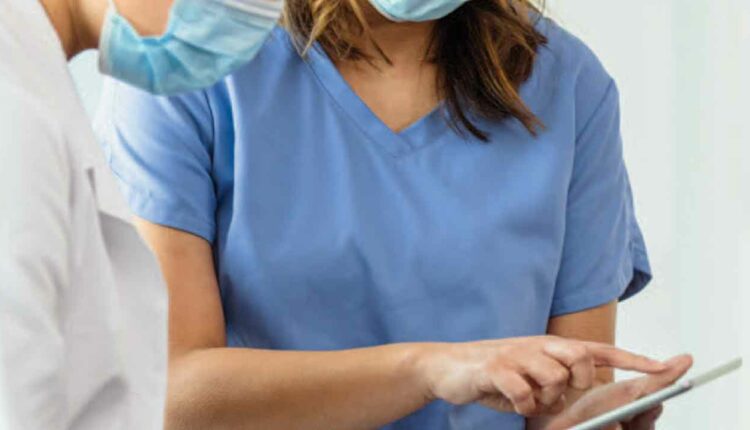 Female dentist and dental hygienist using a tablet