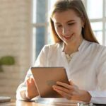 Woman sitting at a table using a tablet