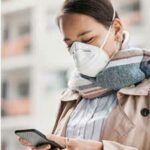 Woman wearing a face mask and looking at her phone