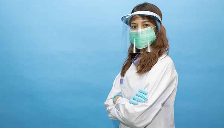 Beautiful dentist wearing surgical mask and face shield.