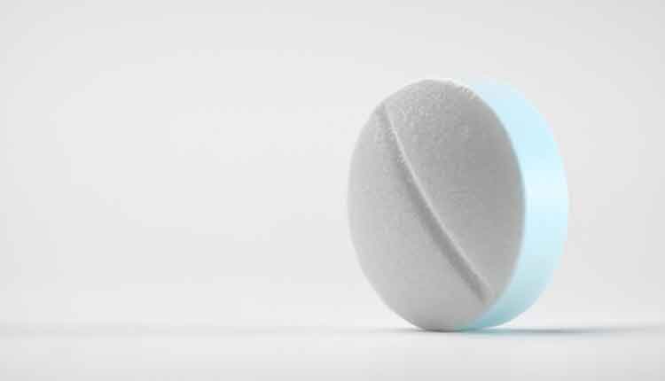 Close-up shot of a round pill on white background