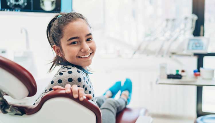 young girl at dentist smiling