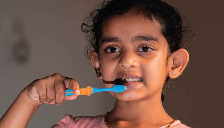 young girl brushing her teeth