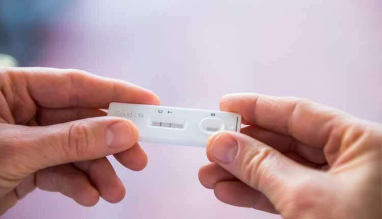 Close up woman hands holding rapid covid -19 test with a positive result.