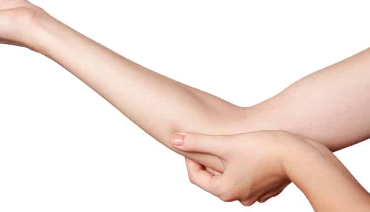 close up of hand holding elbow in pain
