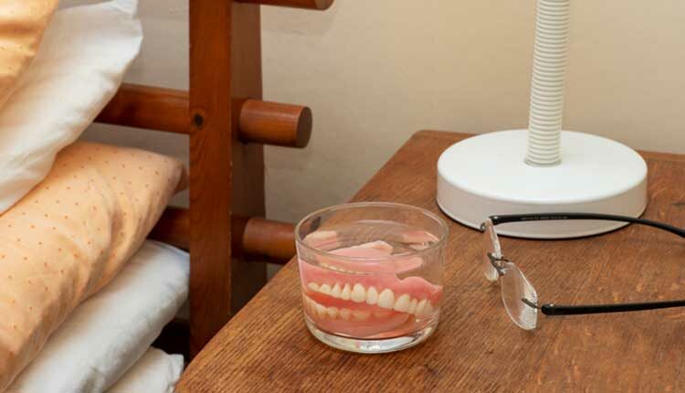 False Teeth and Glasses on a Bedside Table