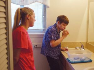 FIGURE 1. The dental prevention coordinator observes selfcare hygiene practices on the visit to the group home. This allows for a realistic assessment of self-care before treatment begins.