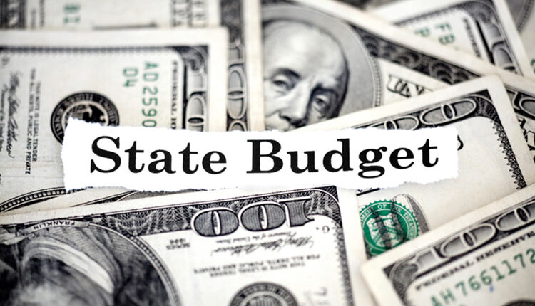A macro shot of the words "state budget" with hundred dollar bills.