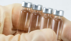 close up of hand holding vials