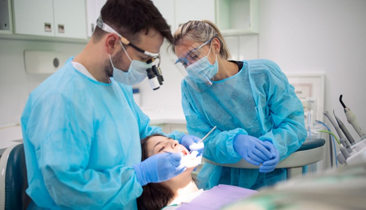 Dentist examining patient mouth in medical clinic.