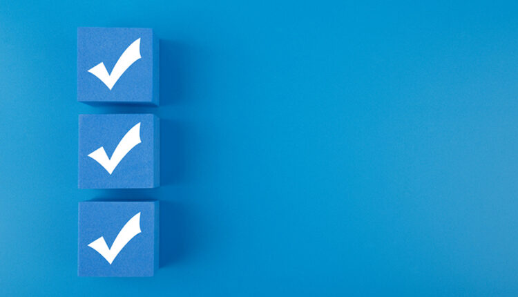Three checkmarks on blue cubes against blue background with copy space