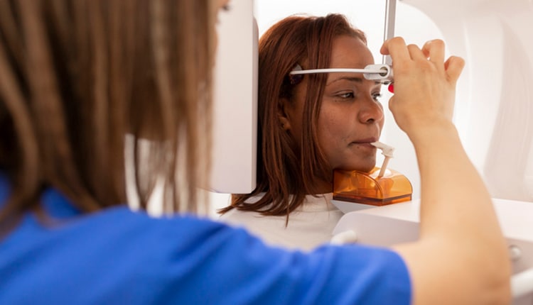 A dentist woman and patient with digital x rays machine at the dental clinic