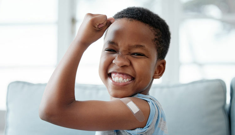 Portrait of a little boy with a plaster on his arm after an injection
