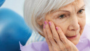 old woman holding her face