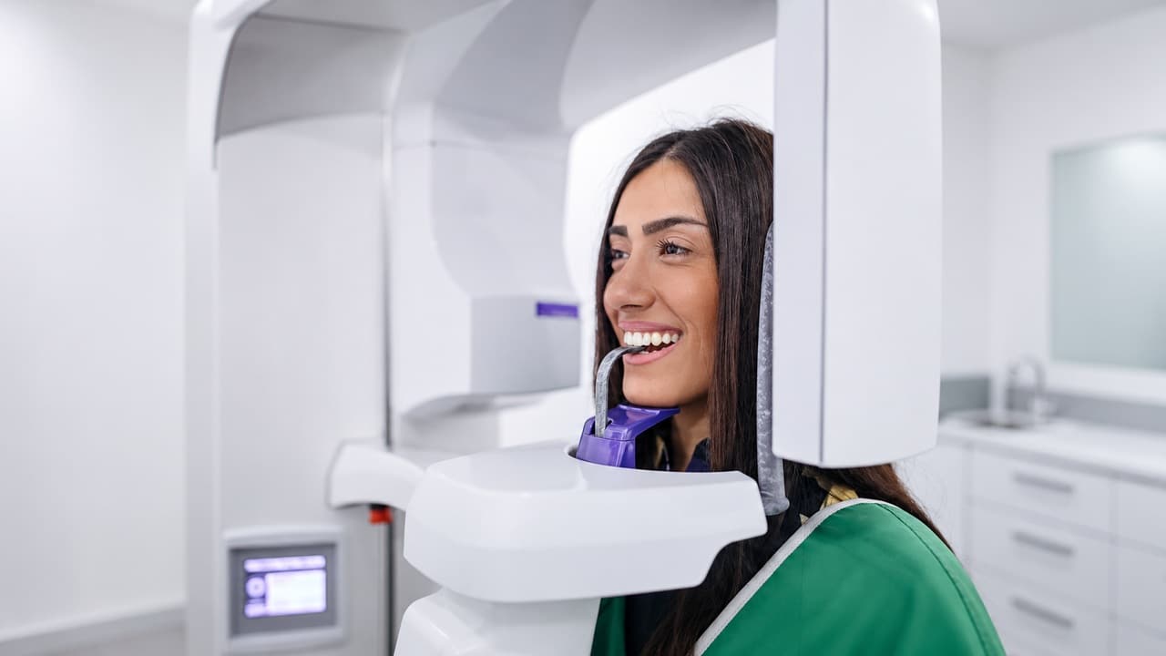 Patient positioned in a panoramic dental X-ray machine