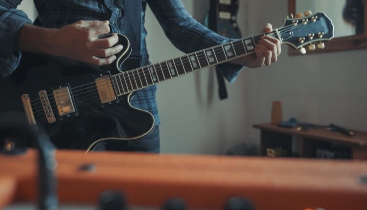 Man playing an electric guitar in a home studio