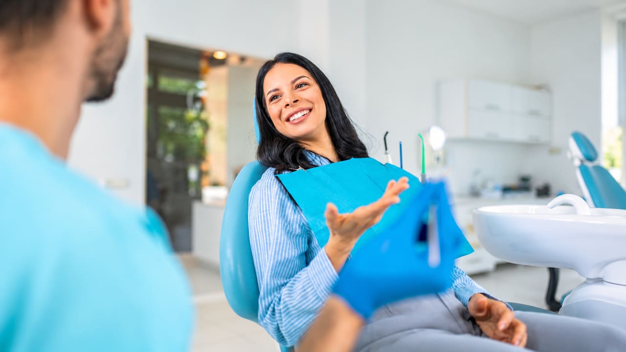 Woman in a dental chair talking with a dental professional